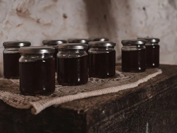 Small jars of homemade fruit preserves set out on a linen runner